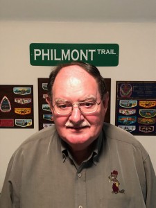 Bil Loeble in his patch room in front of some of the patch plaques from his years as Section Advisor.